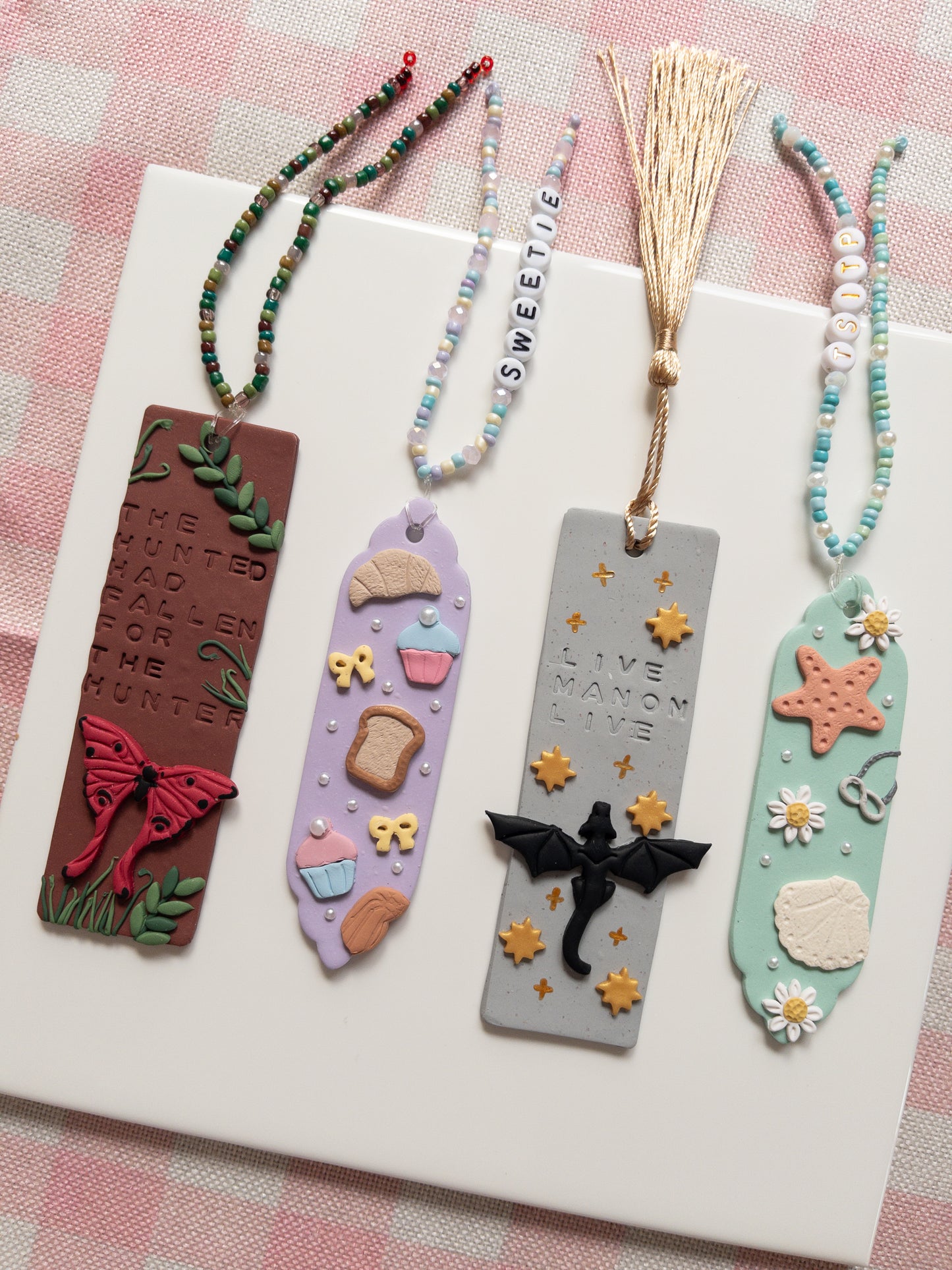 Four decorative bookmarks with unique designs on a white surface.