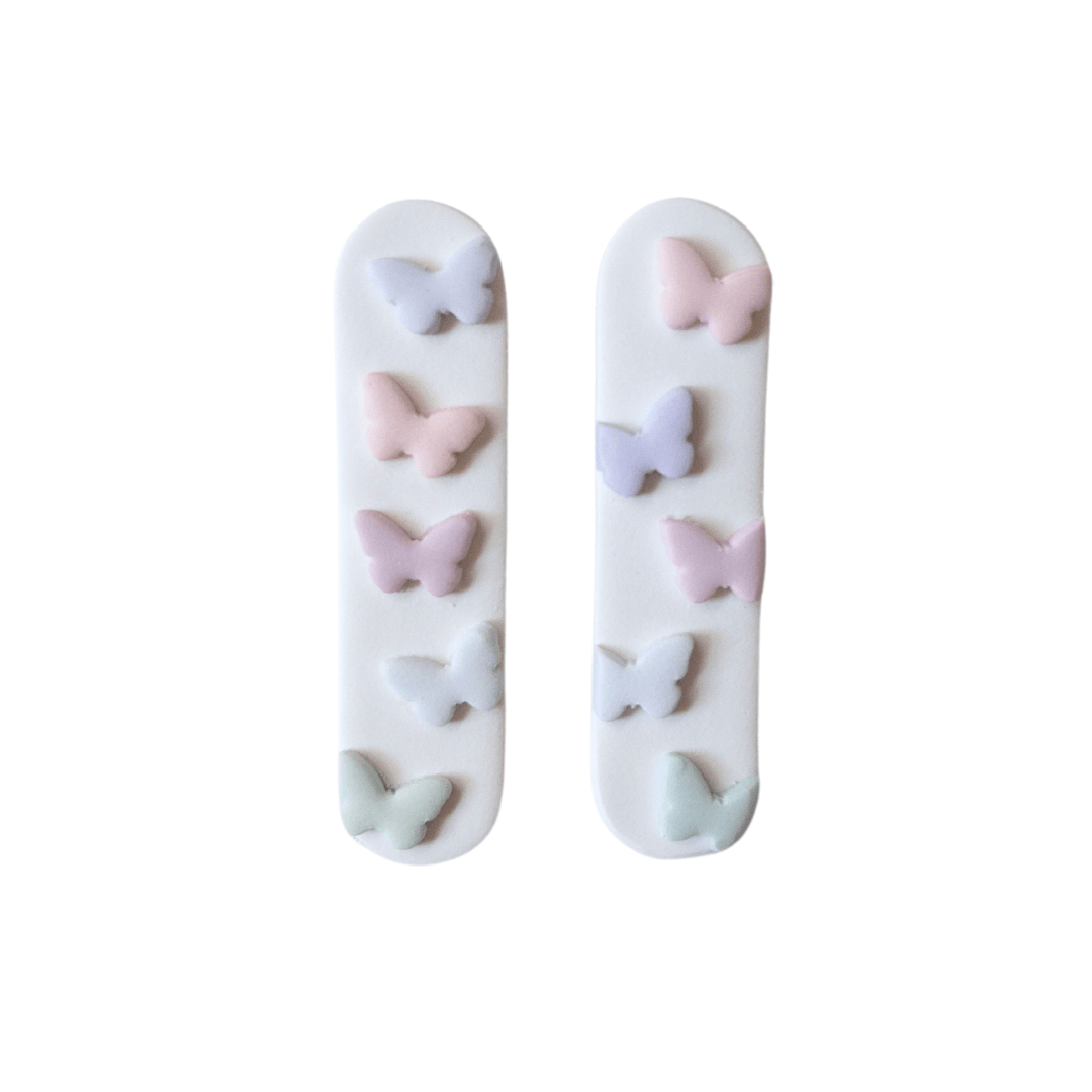 White hair clips with pastel butterfly accents on top