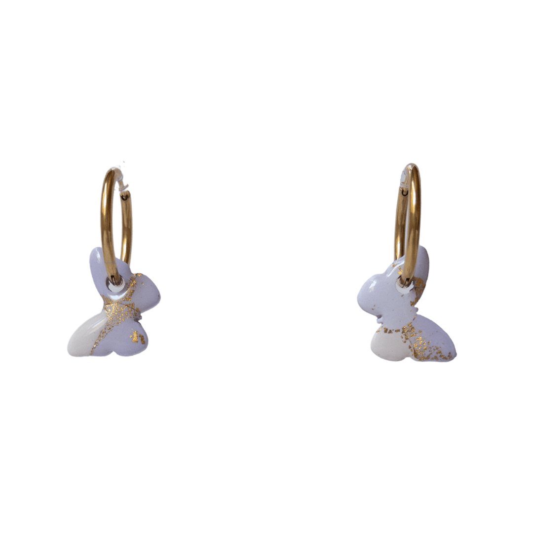 Small Purple and White Butterfly charms with gold flecks, hanging on gold hoops.