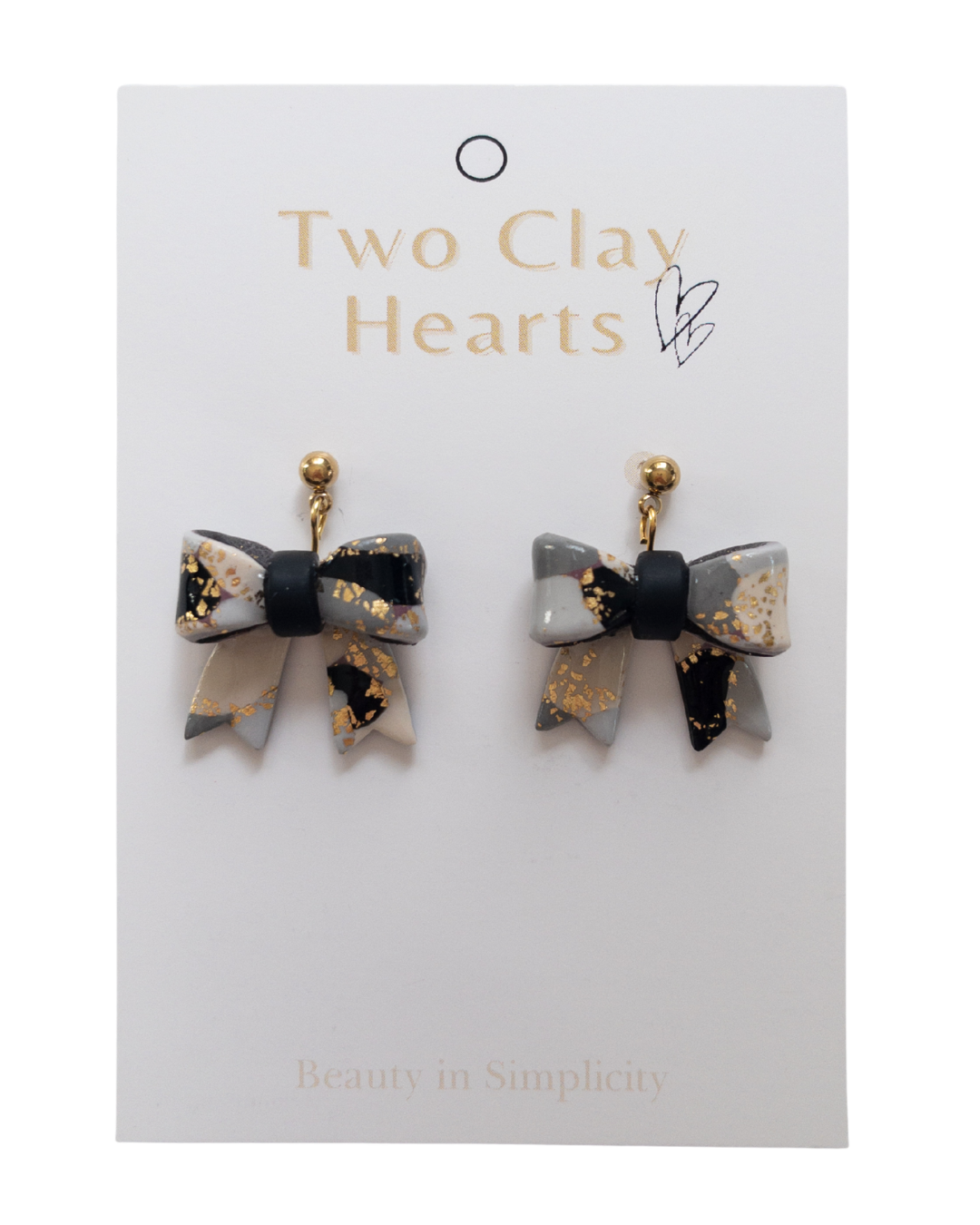 Bow-shaped earrings on a 'Two Clay Hearts' branded card