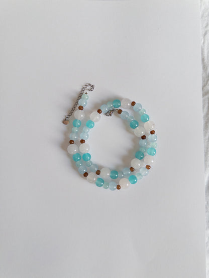 Blue and brown beaded necklace styled on white background