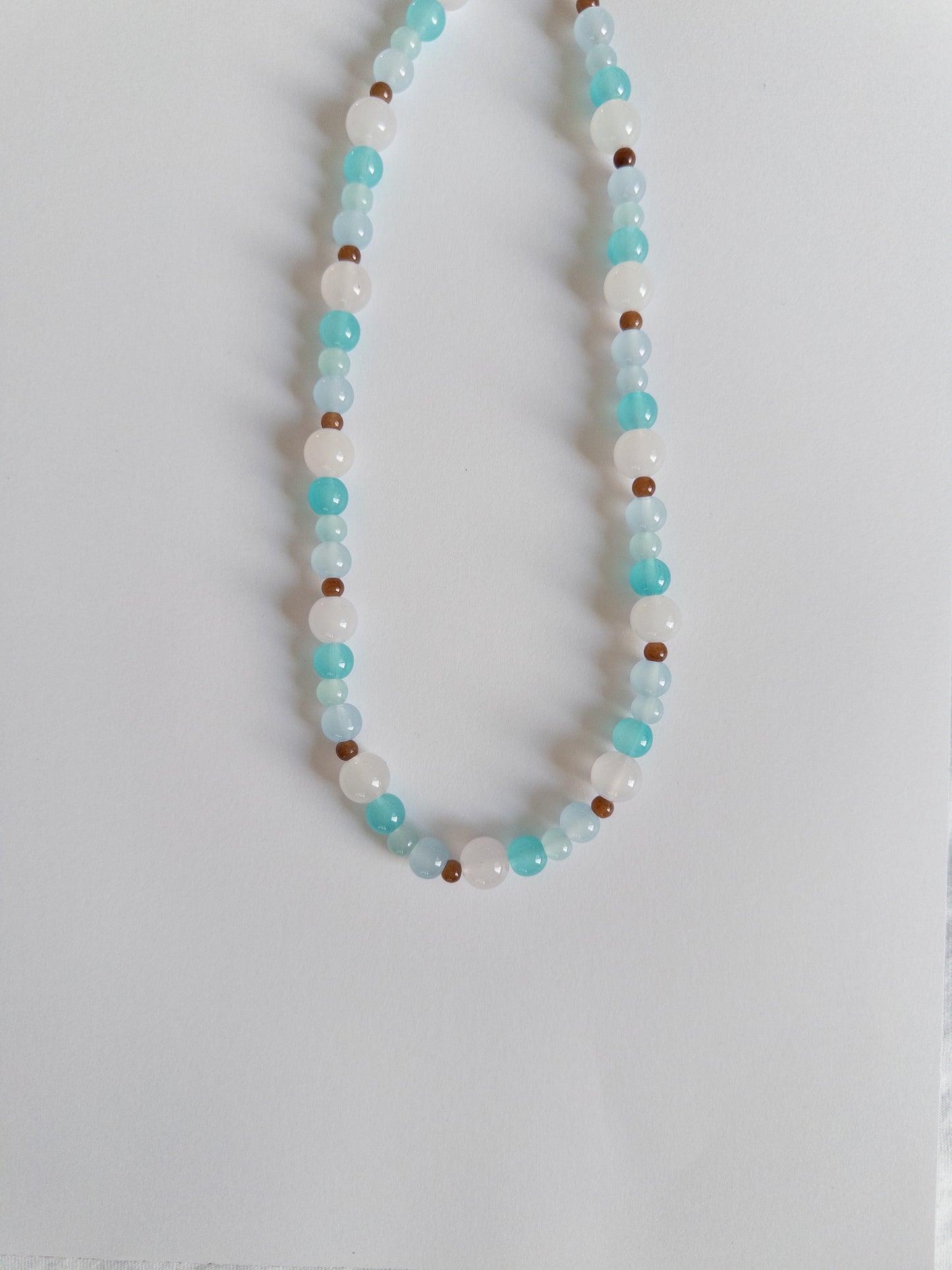 Blue and brown beaded necklace on white background