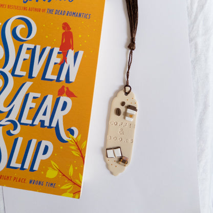 Polymer clay bookmark next to closed book on a white background