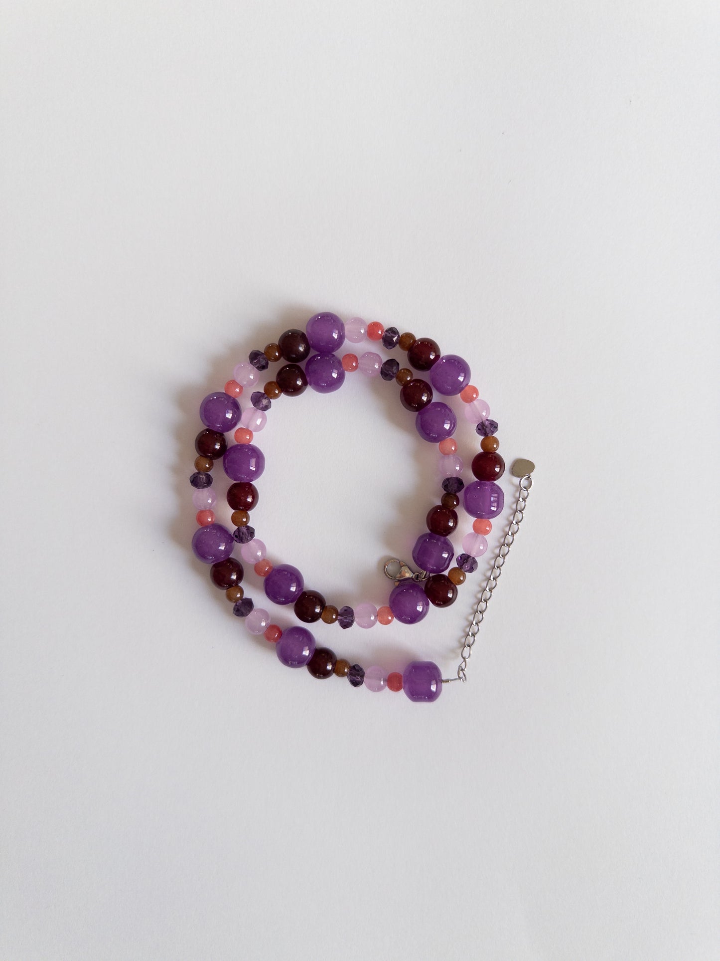 Dark purple glass bead necklace styled on white background