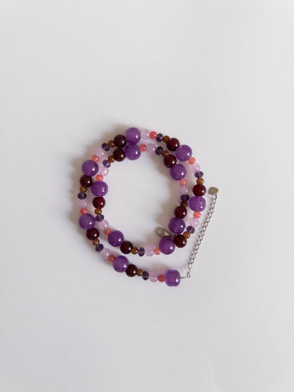 Dark purple glass bead necklace styled on white background