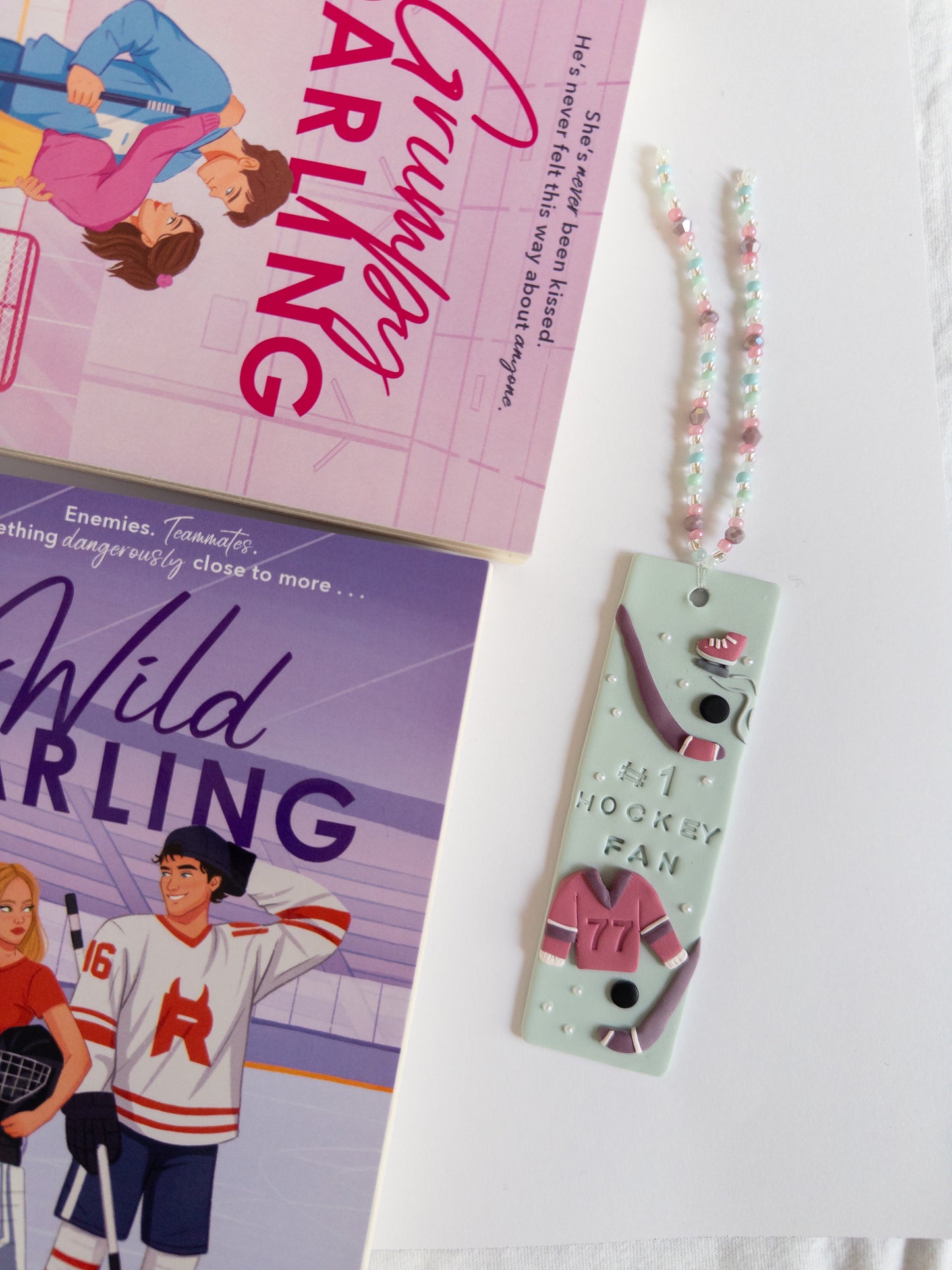 Hockey themed bookmark next to fiction 
hockey books