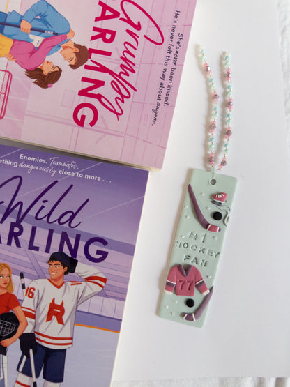 Hockey themed bookmark next to fiction 
hockey books