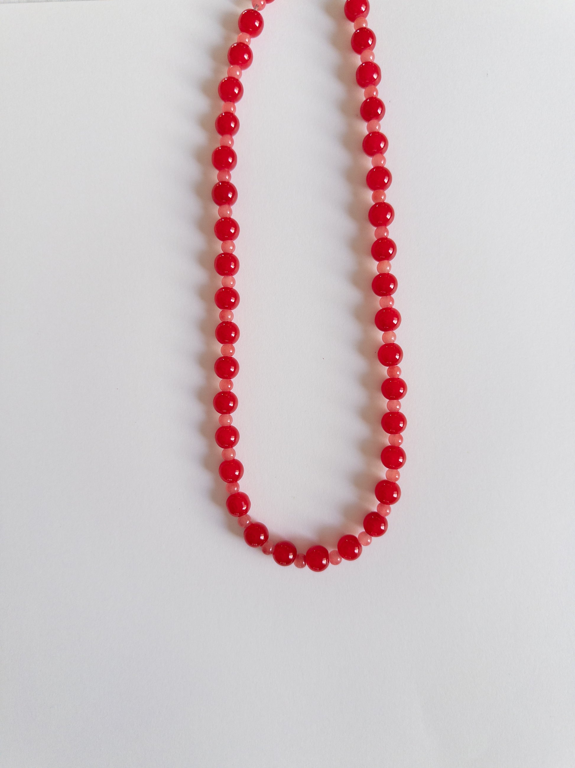 Red beaded necklace on a white background