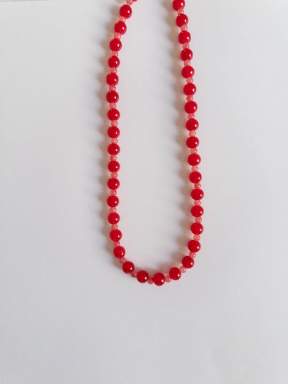 Red beaded necklace on a white background
