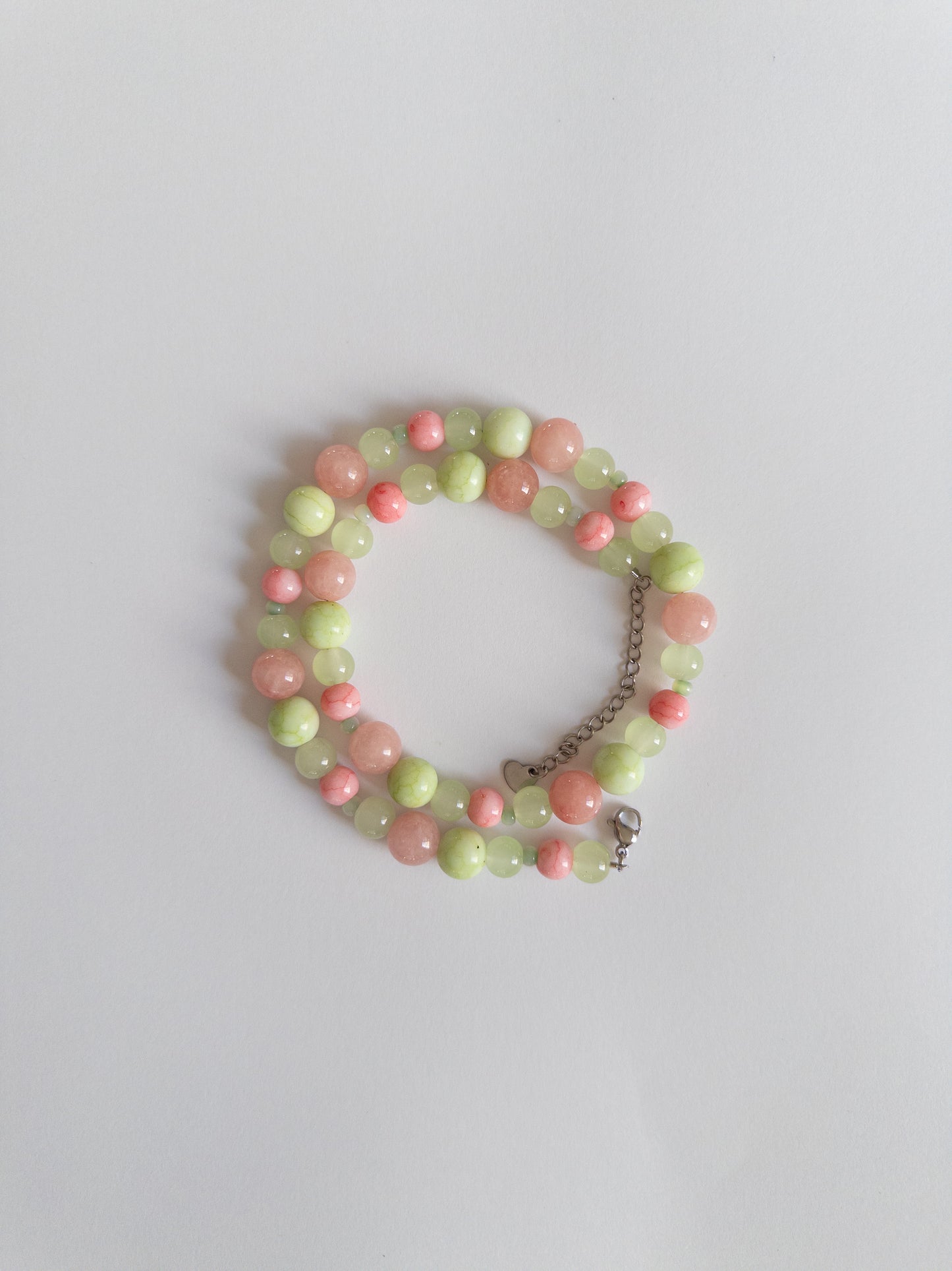 Pink and Green glass bead necklace styled on white background
