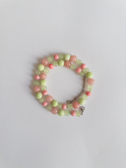 Pink and Green glass bead necklace styled on white background