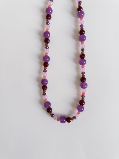 Dark purple glass bead necklace on white background