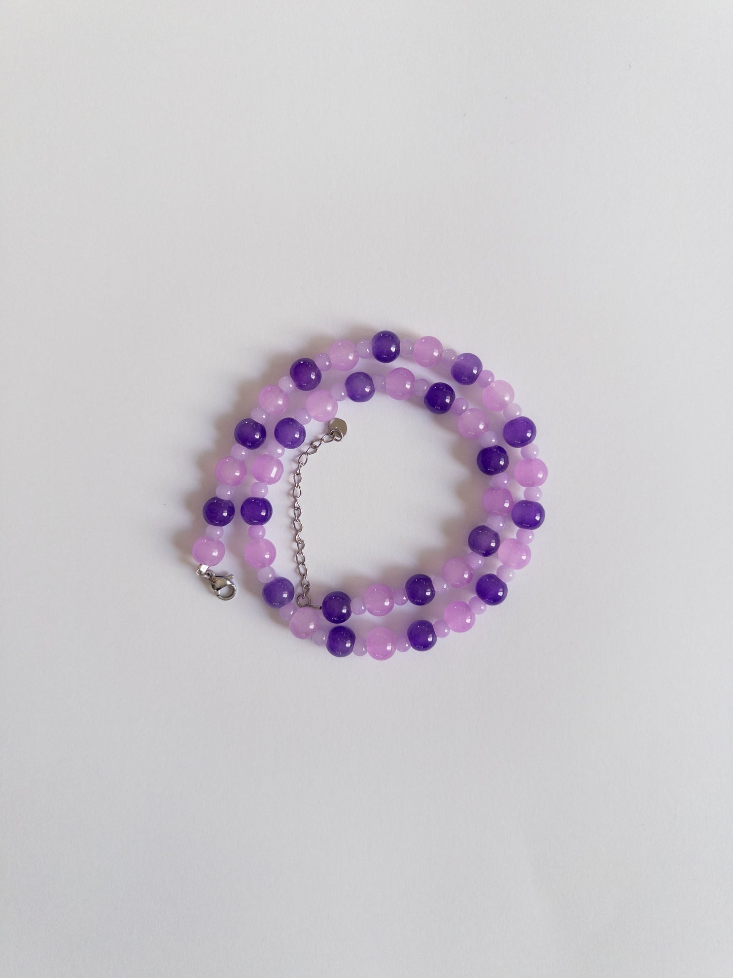 Dark and Light purple beaded necklace styled on white background