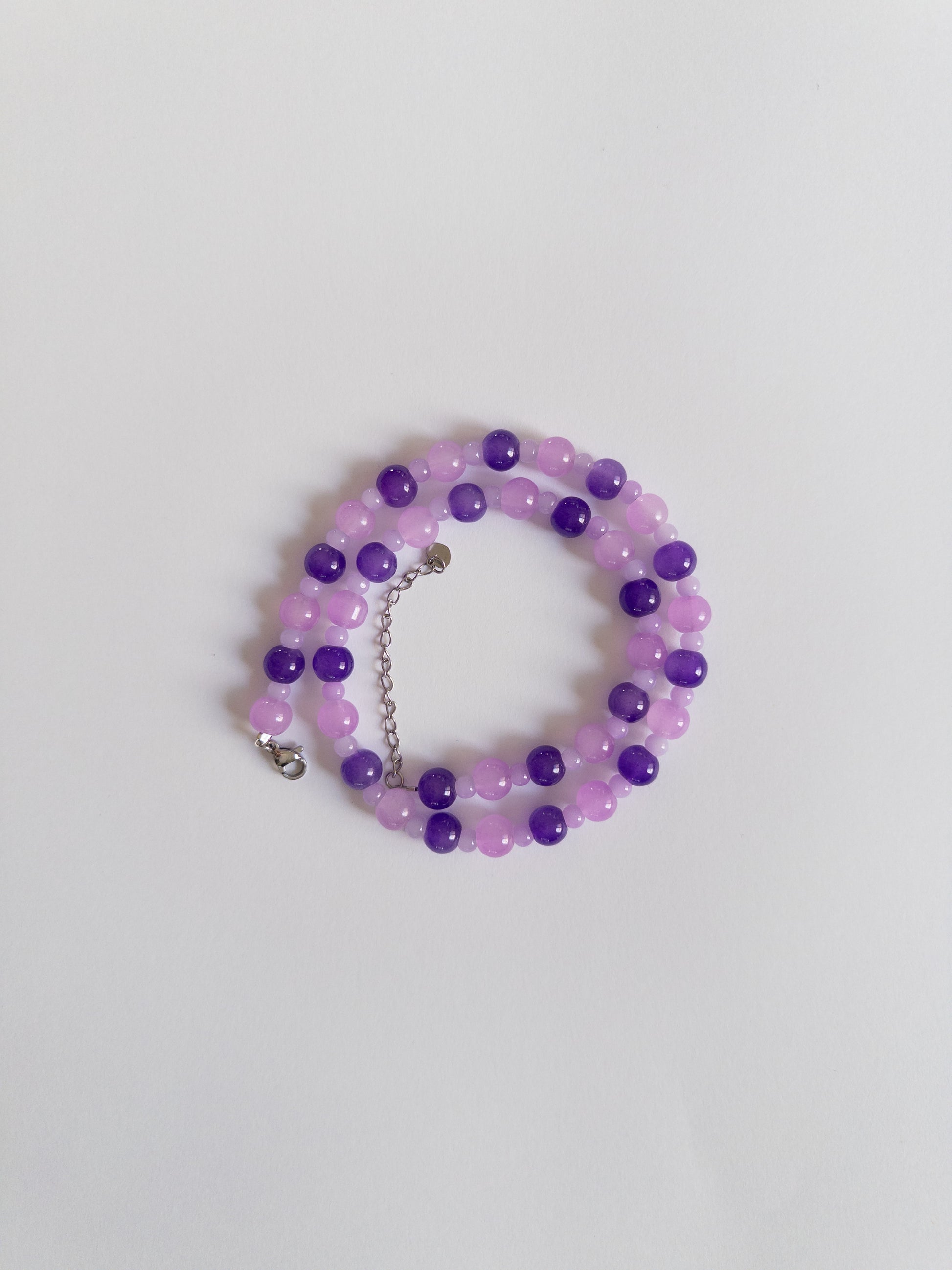 Dark and Light purple beaded necklace styled on white background