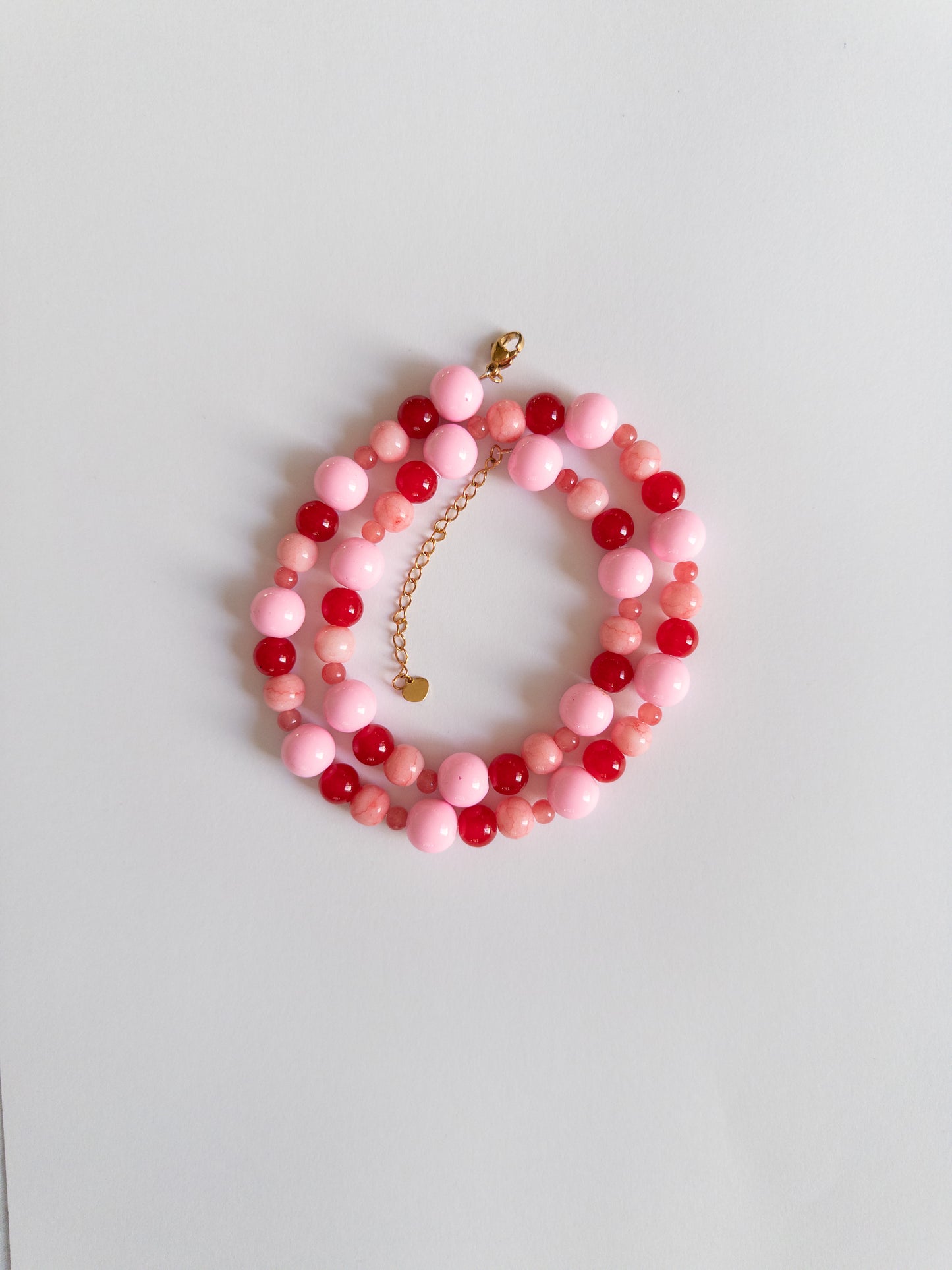 Red and Pink chunky beaded necklace styled on a white background