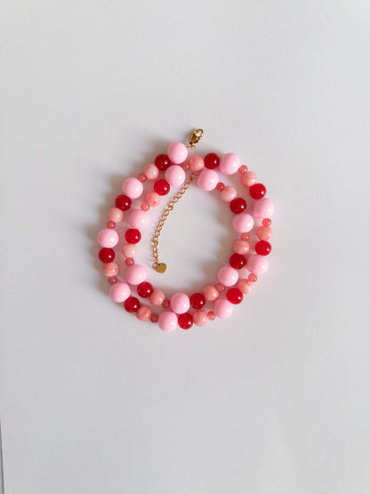 Red and Pink chunky beaded necklace styled on a white background