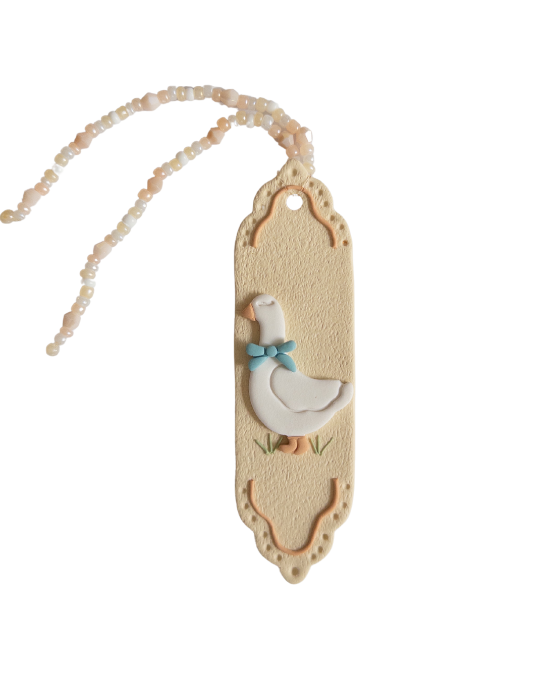 Beige coloured polymer clay bookmark with a white goose on it and a beige and white beaded tassel
