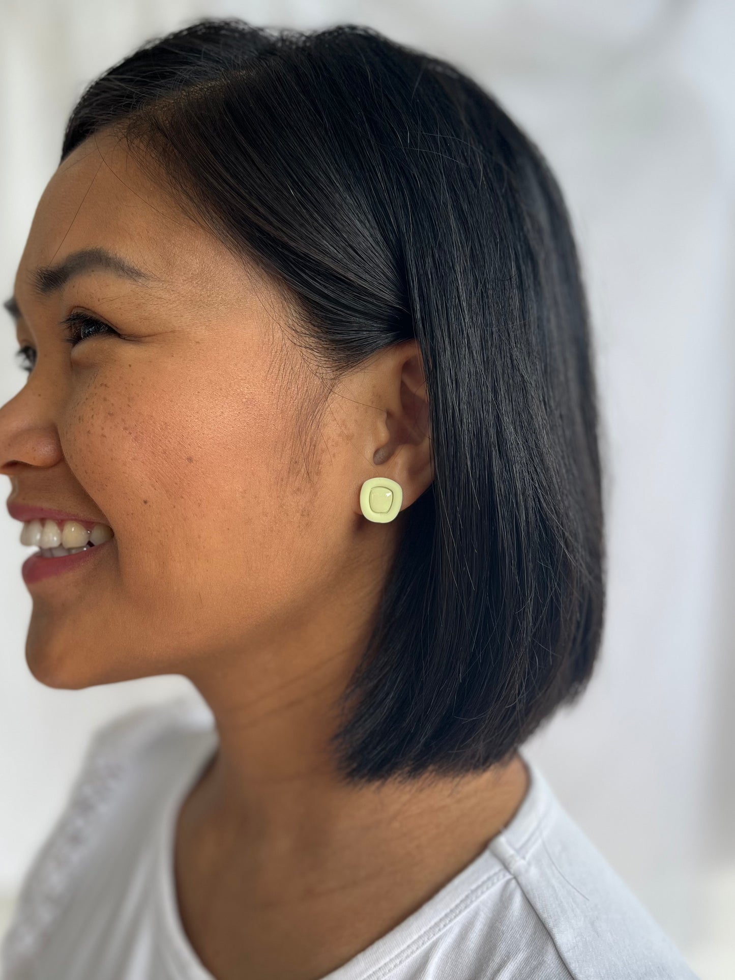 Green resin centred earrings on models ear