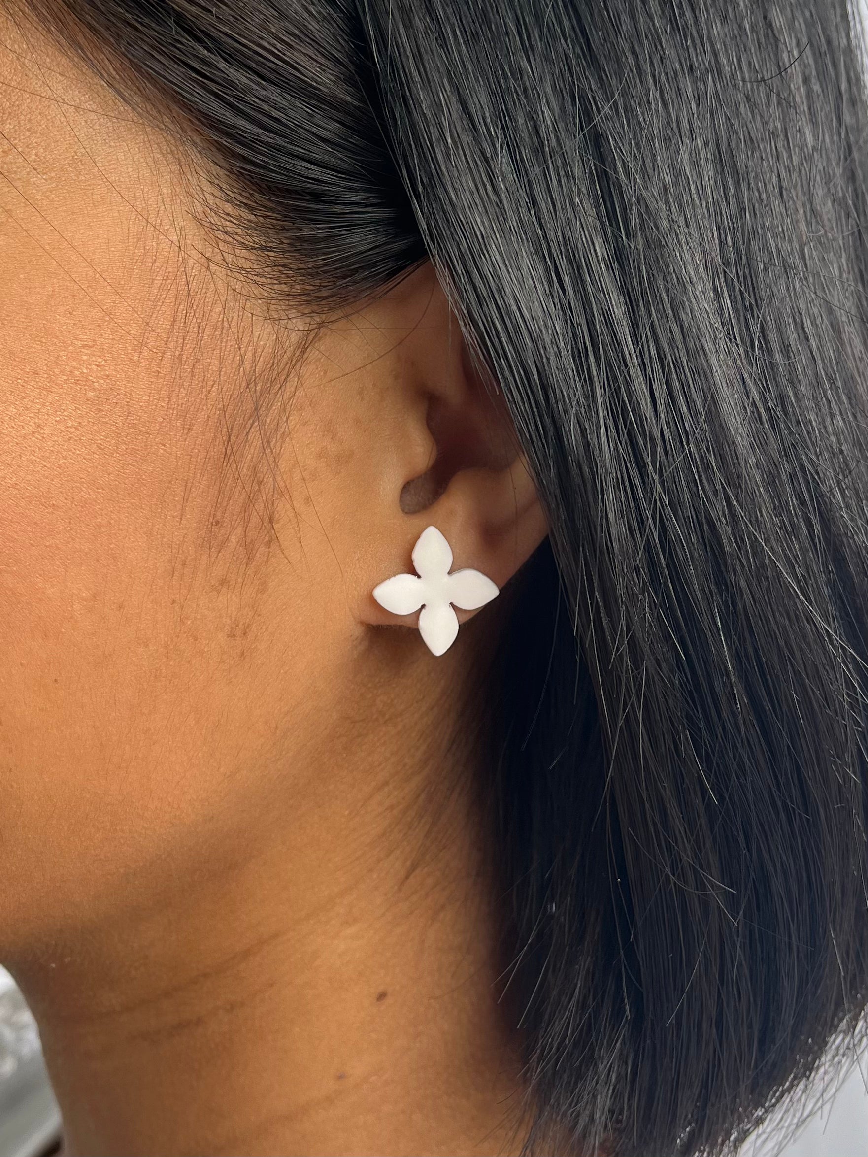 White Green, four petalled flower stud earring on models ear