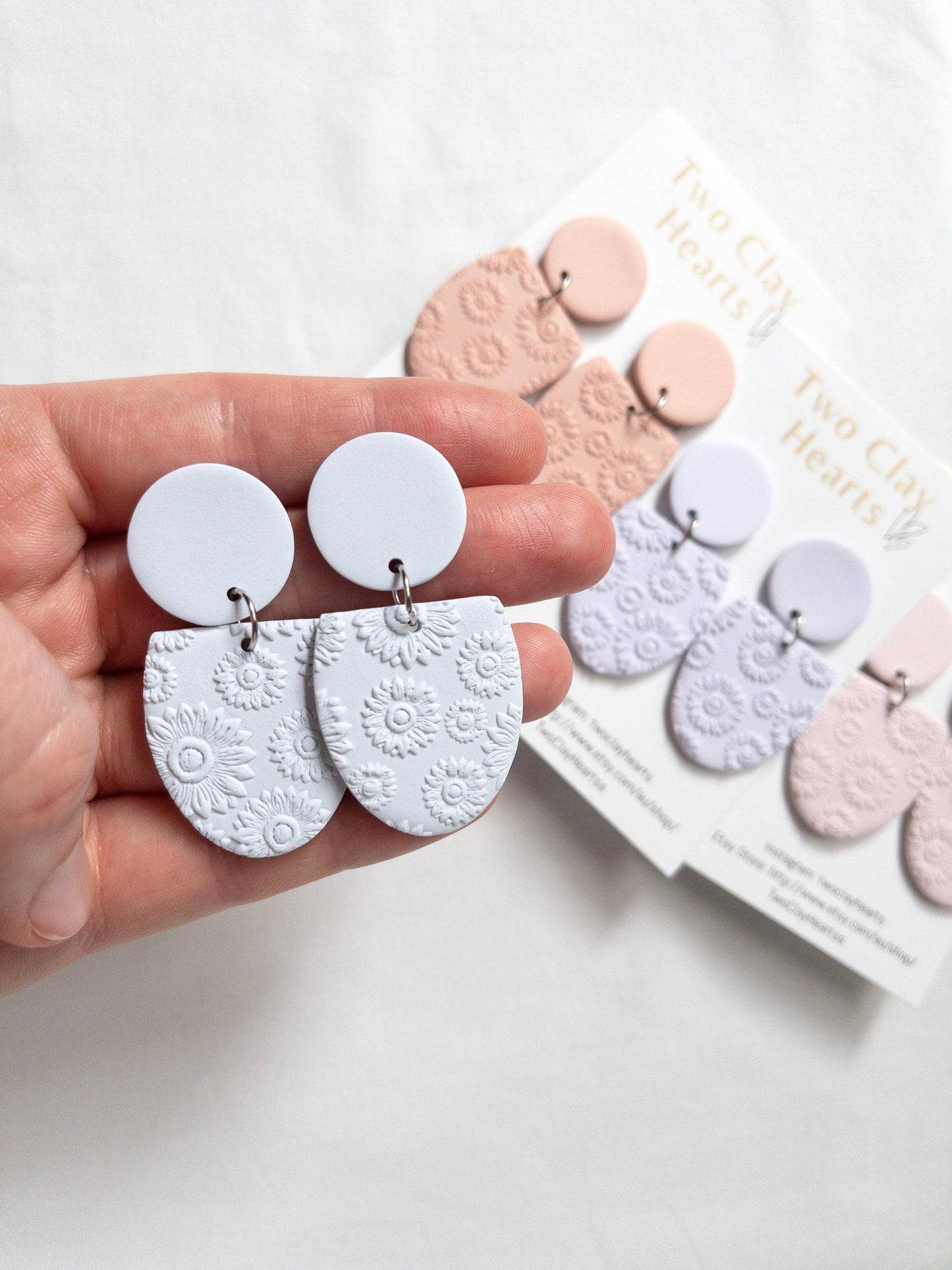 A range of half oval earrings in pastel colours and with a flower print