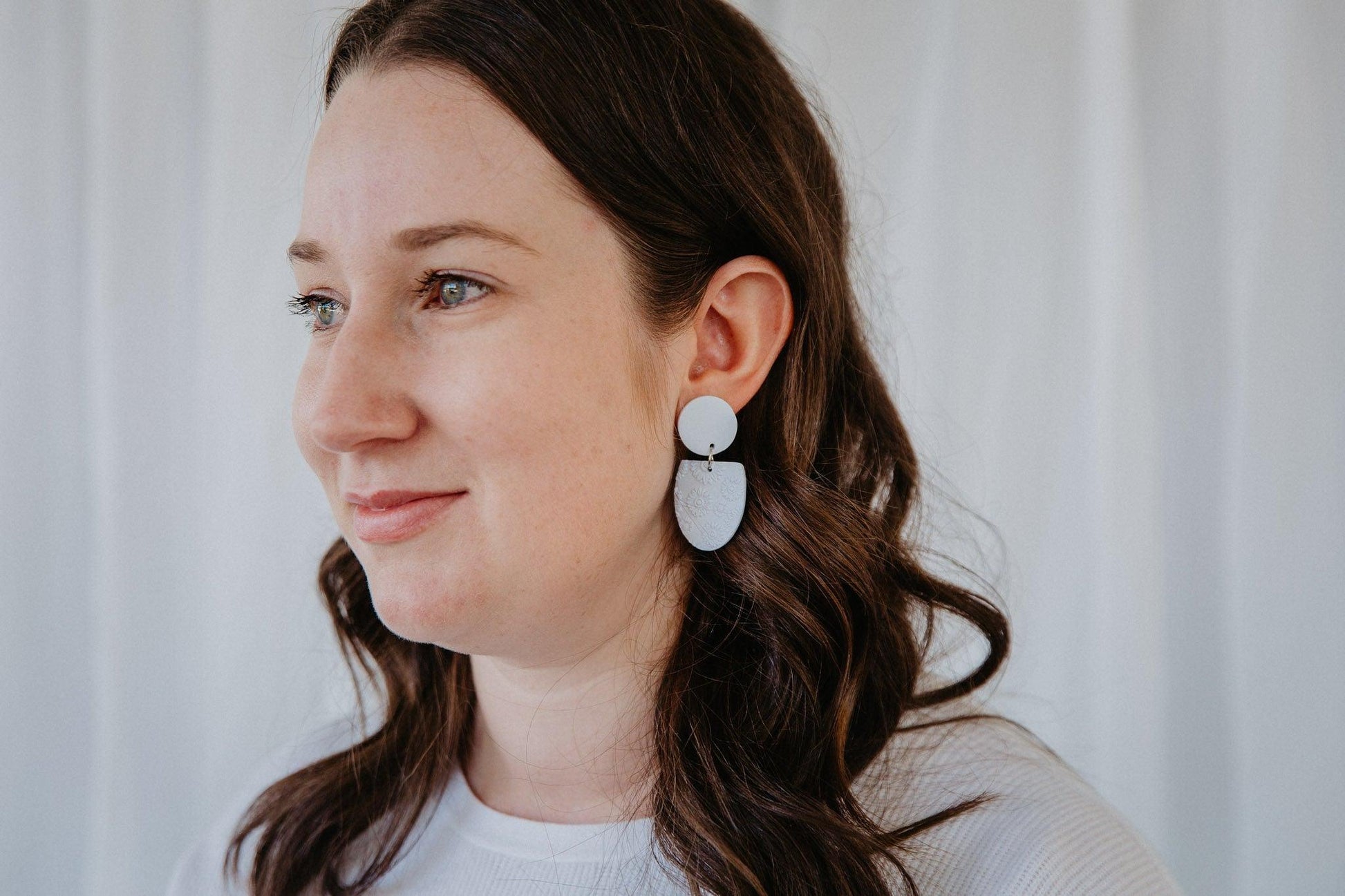 blue oval earrings with flower print worn on a model