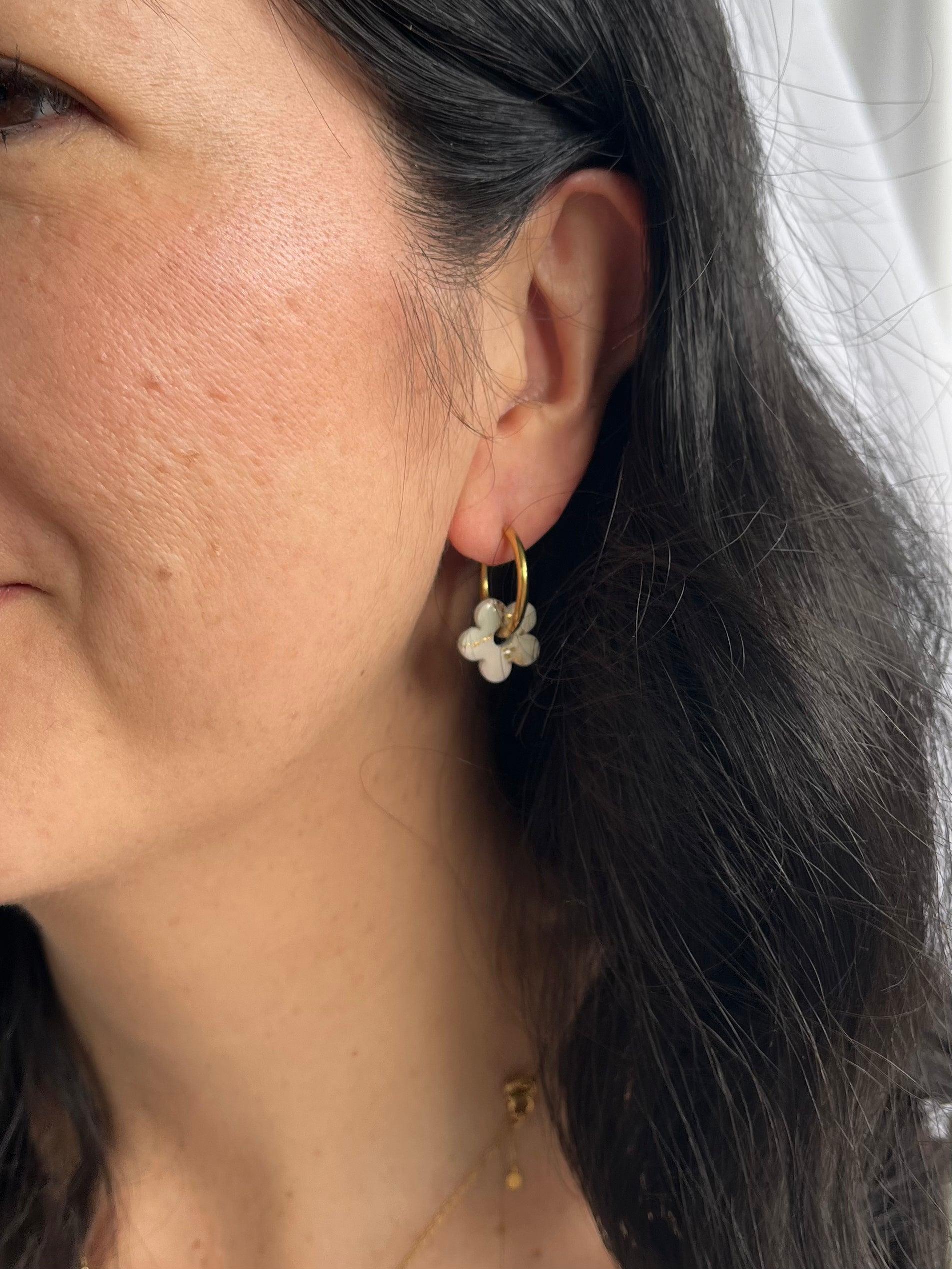 Gold flower hoop on model with dark hair