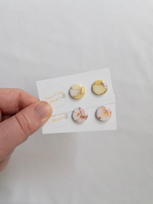 Pastel and gold circle shaped stud earrings on white backing card