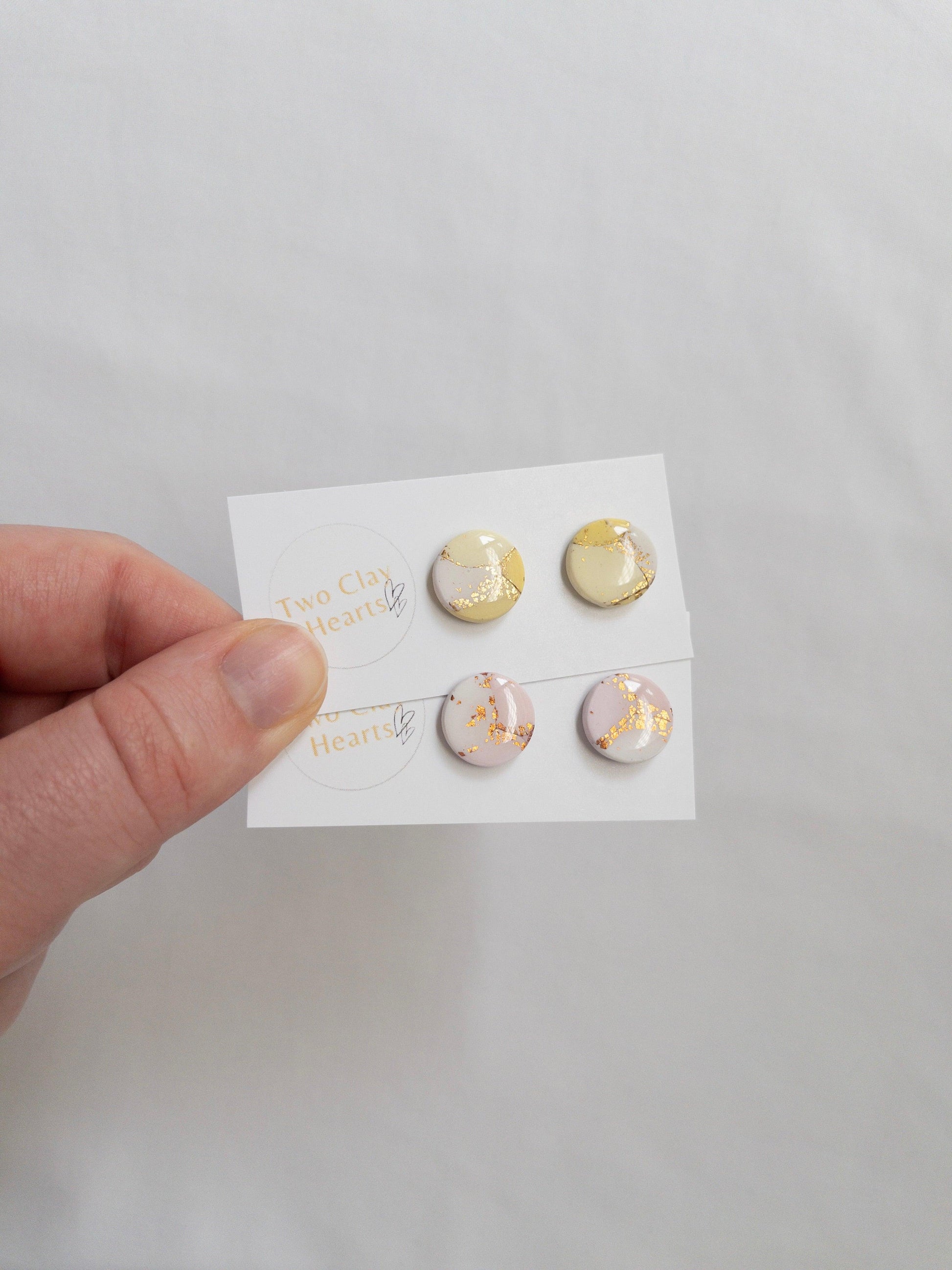 Pastel and gold circle shaped stud earrings on white backing card