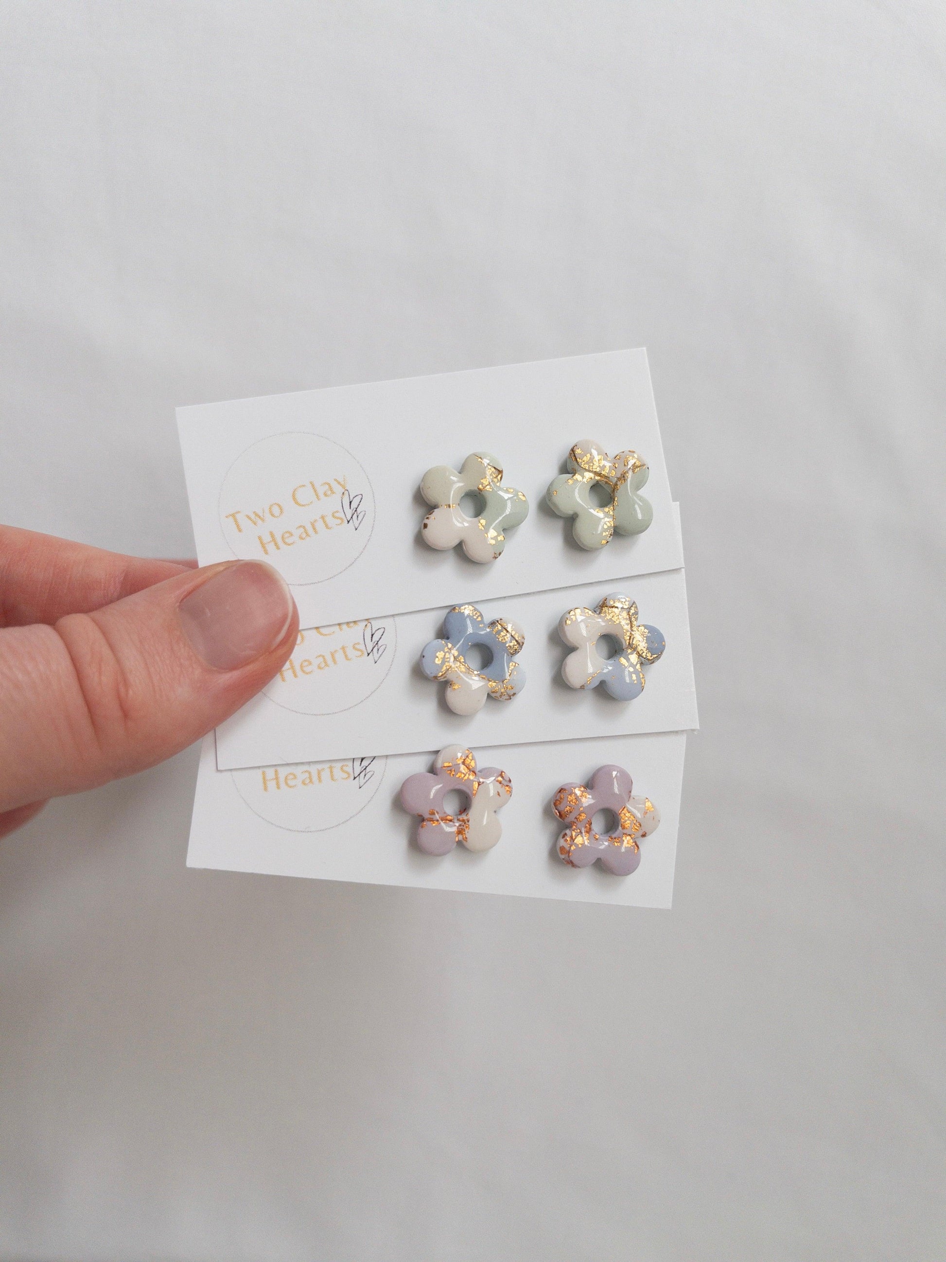 Shiny pastel flower stud earrings on white backing cards