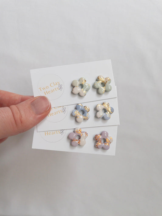 Shiny pastel flower stud earrings on white backing cards