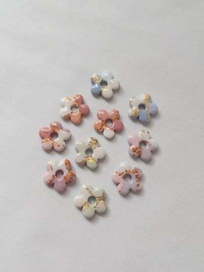 Shiny pastel flower stud earrings on white backdrop