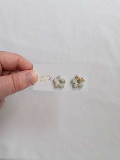 Green and gold flower stud earrings on white backing card