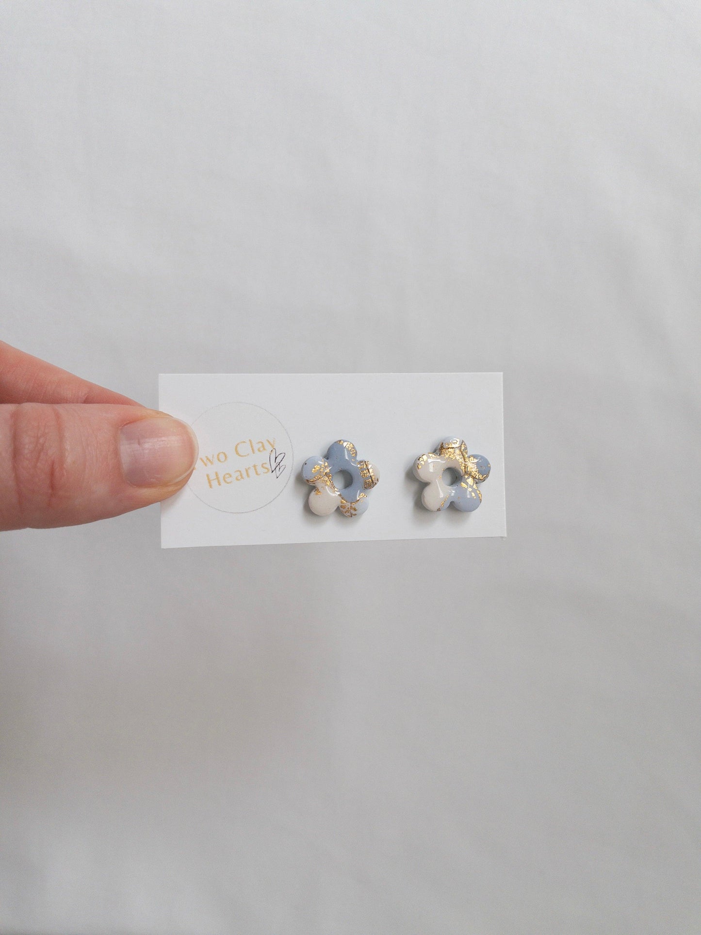 Blue and gold flower stud earrings on white backing card