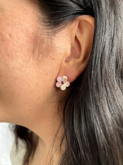 Purple flower stud earrings on models ear