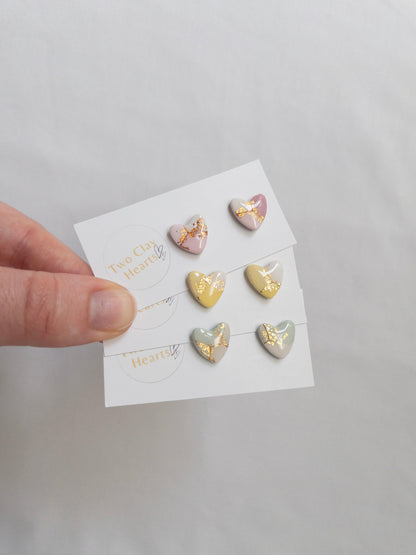 Pastel and gold heart shaped stud earrings on white backing card