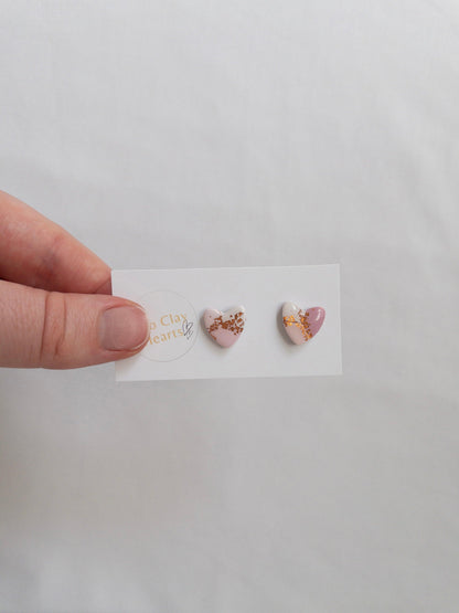 Pink and rose gold heart shaped stud earrings on white backing card