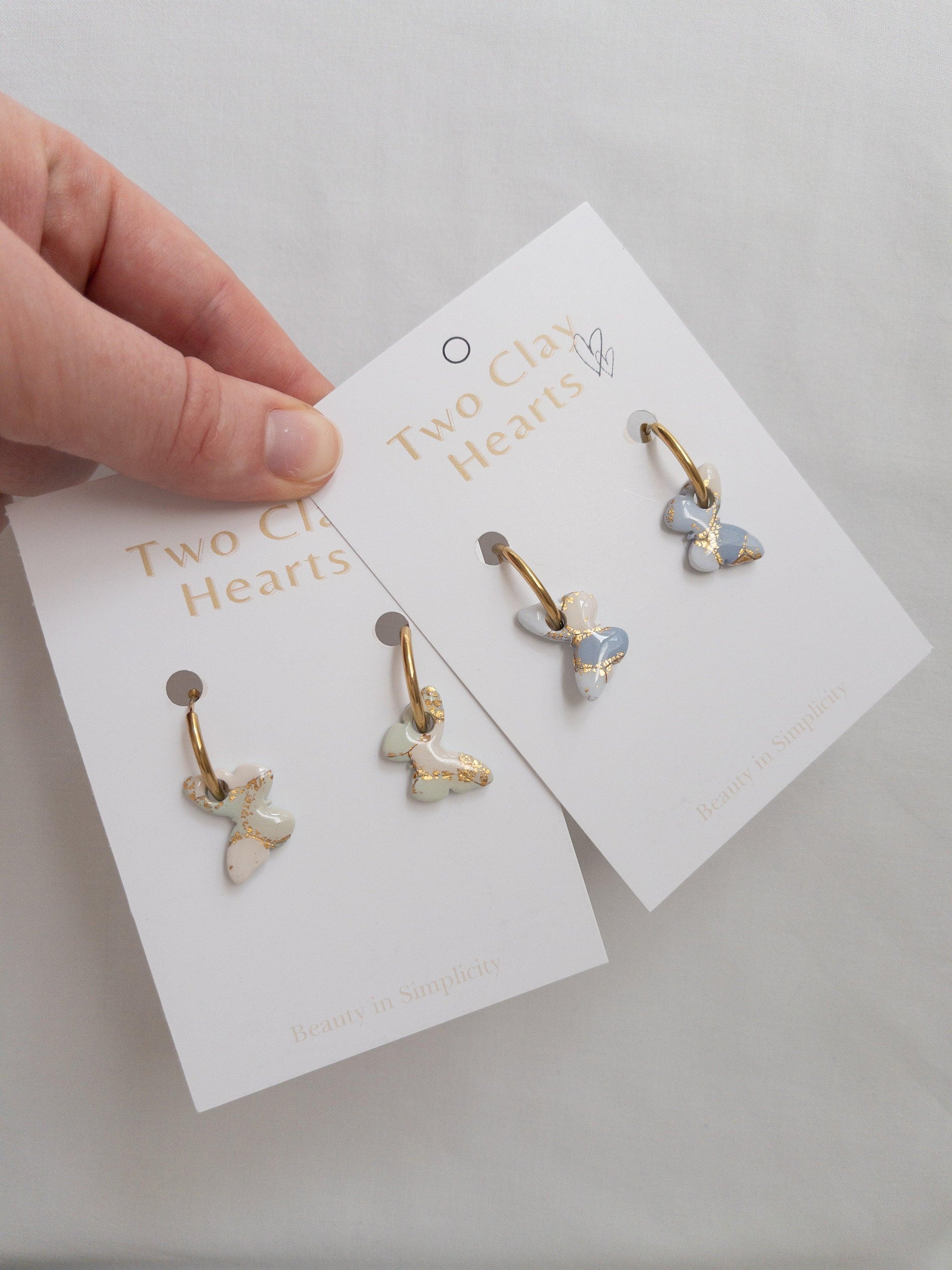 Gold butterfly hoop earrings on backing cards