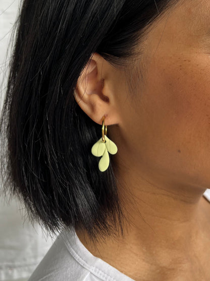 Close up of leaf hoop earrings on model