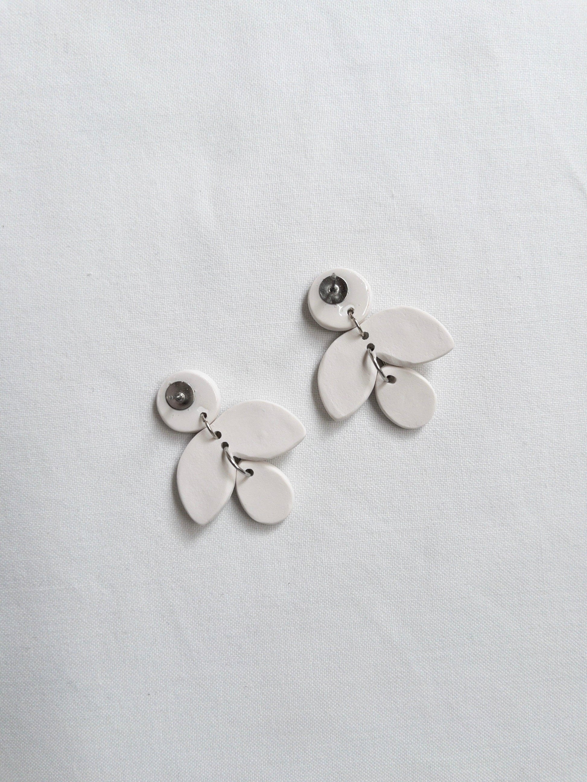 Upside down earrings on a white cloth showing the stainless steel backings