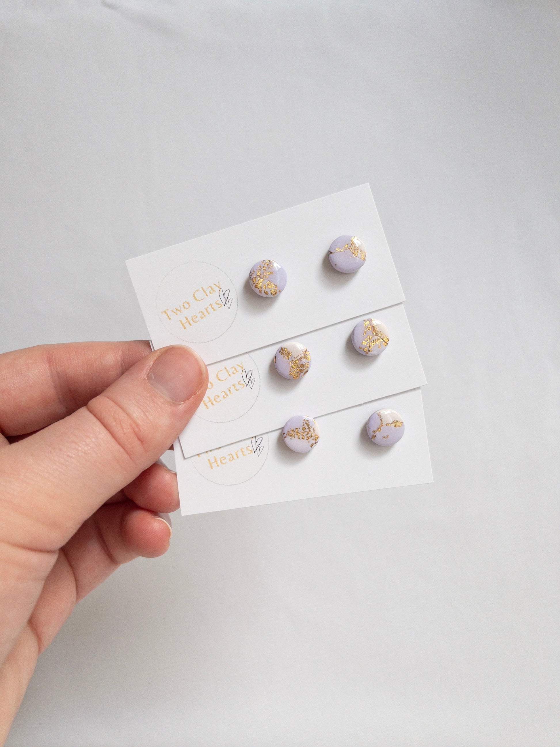 pairs of small circle stud earrings in purple and gold colours