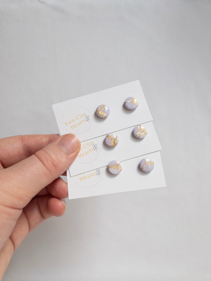 small purple circle earrings with gold specks. The gold specks are shining in the sun