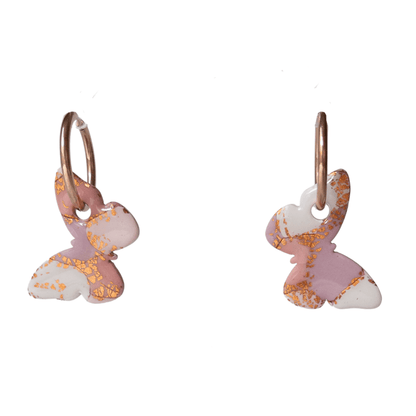 Close up on pink and rose gold large butterfly hoop earrings