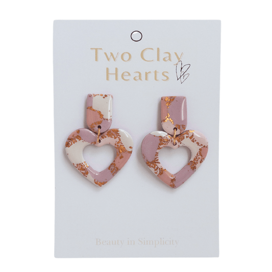 Pink and rose gold heart dangle earrings on white backing card