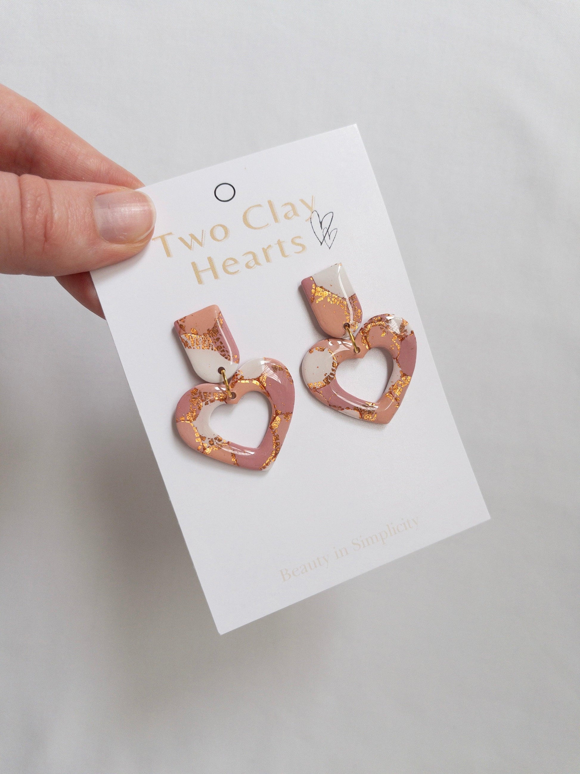 Maroon, Orange and Rose Gold Love Heart Dangle earrings on white backing card