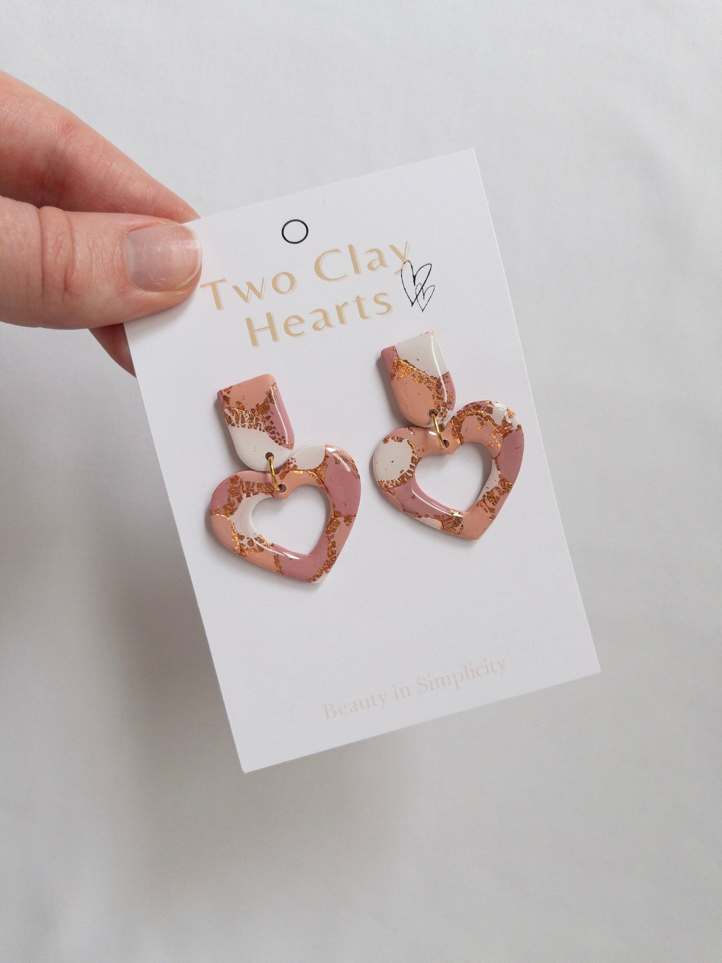 Maroon, Orange and Rose Gold Love Heart Dangle earrings on white backing cards