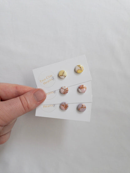 Mini pastel and gold circle stud earrings on white backing card