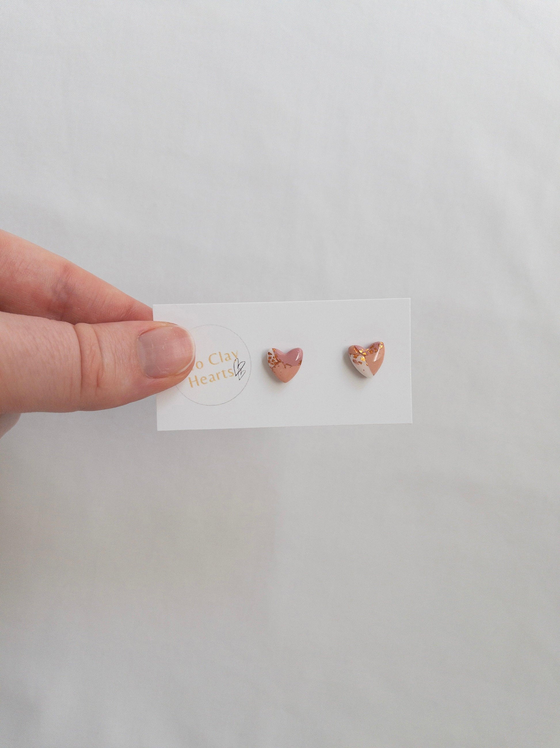 Mini maroon and rose gold heart stud earrings on white card