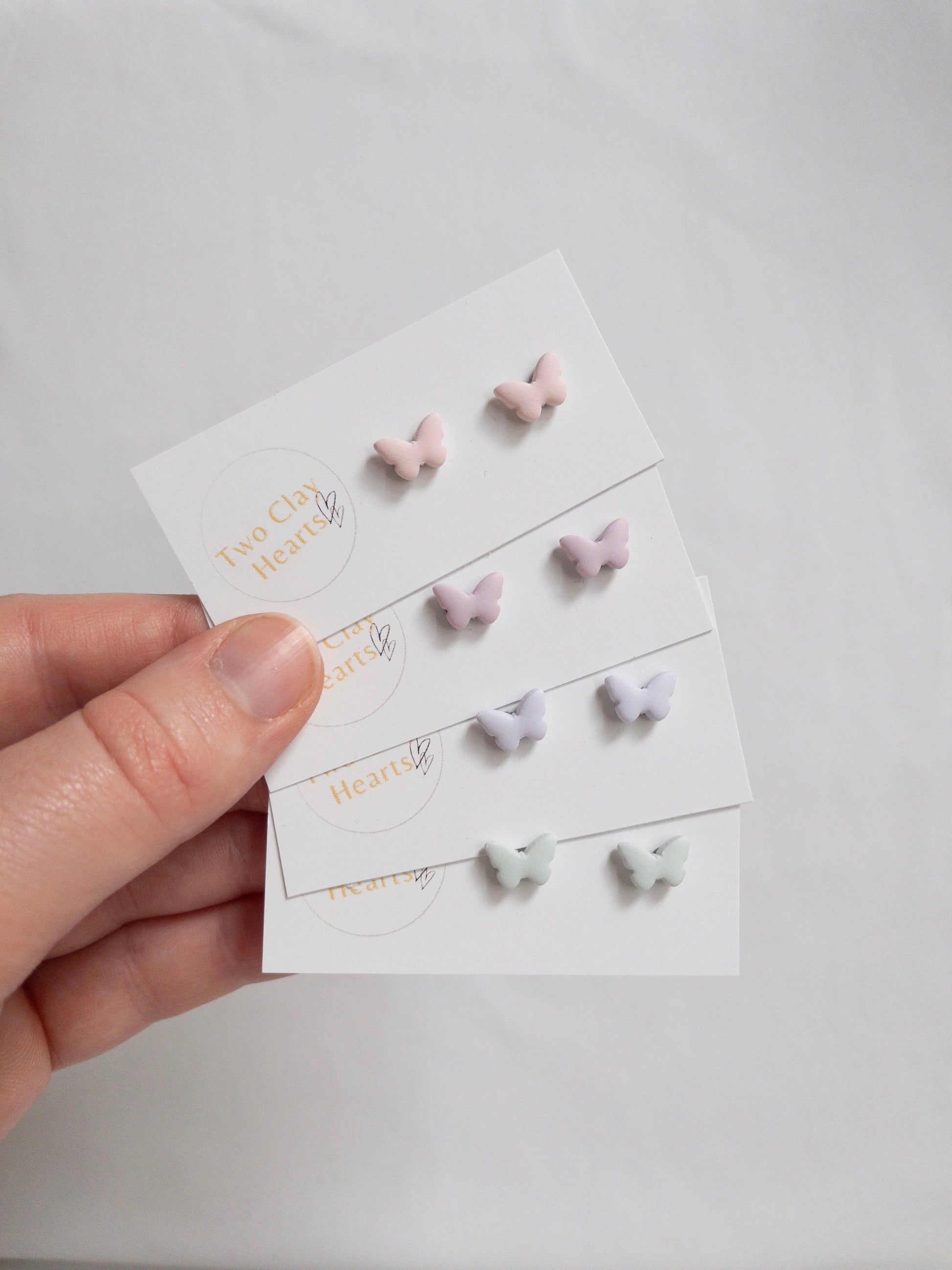 Pairs of tiny pastel  butterfly earrings each in a different colour.