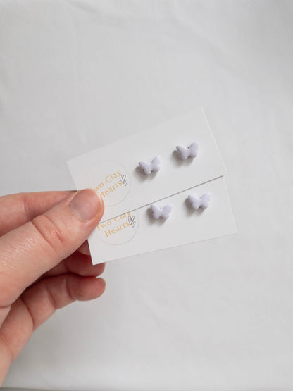 Pairs of tiny pastel purple butterfly earrings.