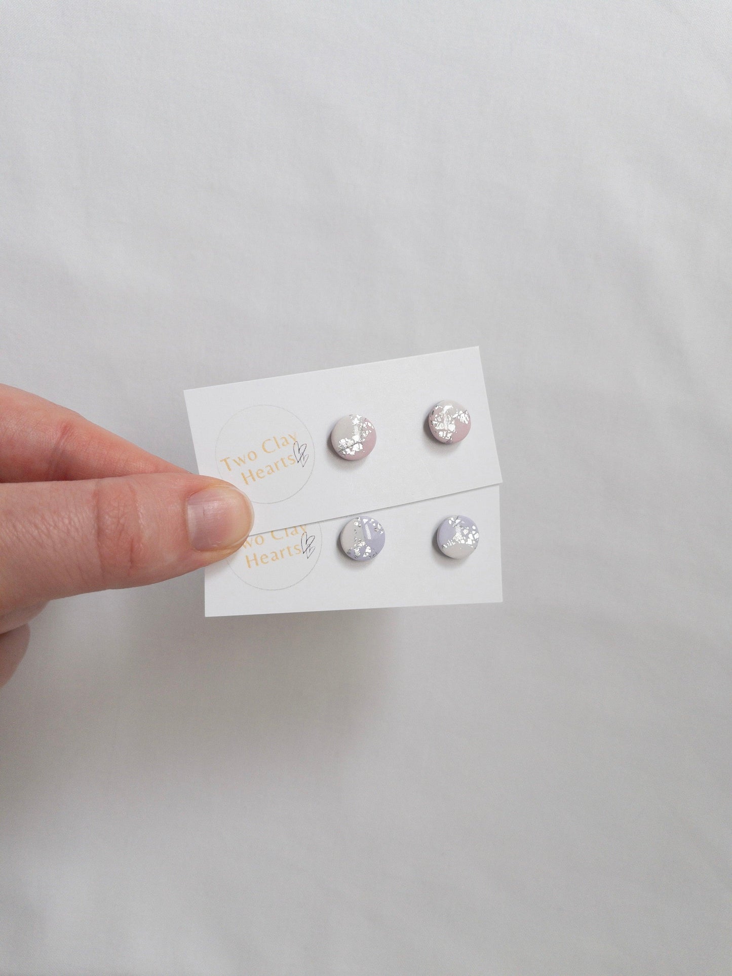 Mini pastel and silver circle stud earrings on white backing card